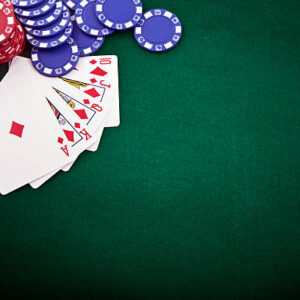 Royal flush and gambling chip on a green poker table