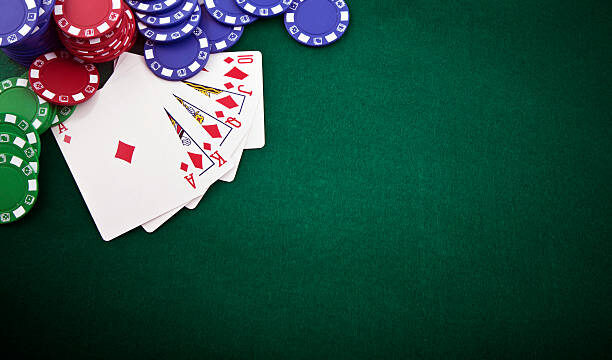 Royal flush and gambling chip on a green poker table