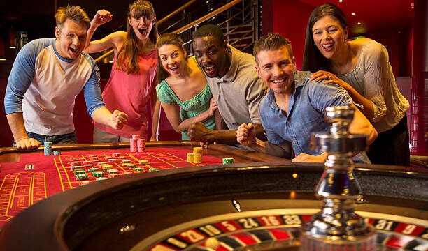 Group Of Friends Playing Roulette In Casino